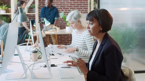 Business woman, computer and documents for audit, tax and financial growth in a busy office