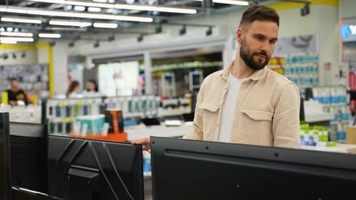 Customer Examining Television in Electronics Store on Black Friday
