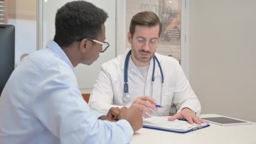 Doctor Discussing Medical Report with Patient in Clinic