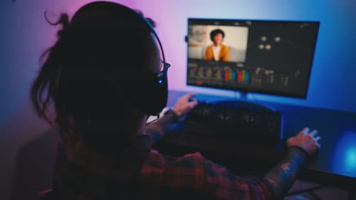 Adult Using Computer Video Editing Software at Night