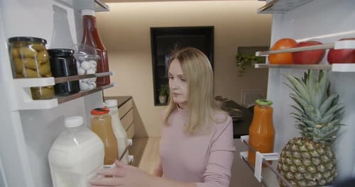 Woman Getting Gallon of Milk From Refrigerator