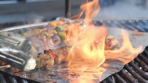 Juicy Meat Skewers with Vegetables Grill on Aluminum Foil Over a Powerful Street Barbecue Bright