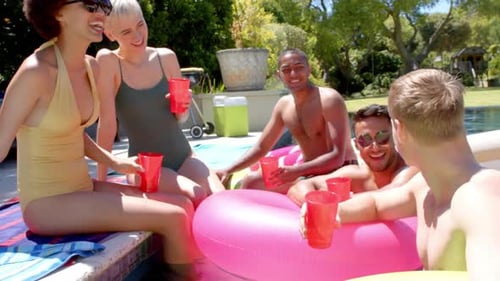 Happy diverse friends drinking drinks at pool party in summer
