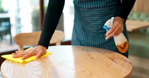 Waitress hands, spray and cleaning table for hygiene, bacteria or shine in coffee shop with liquid