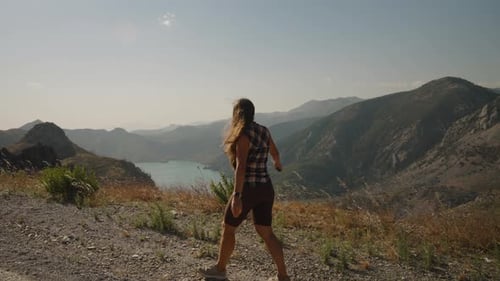 Woman Joyfully Spreads Her Arms, Embracing the Freedom of Nature, Stunning Mountain and Lake View.