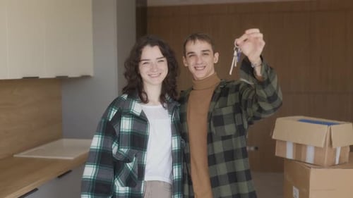 Happy Couple Embraces in New Apartment As Husband Holds the Keys Proudly
