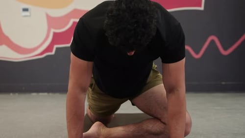 Man stretching on the workout mat, front view