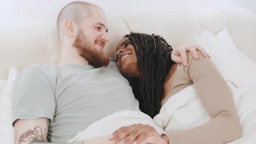 Loving Couple Embrace in Bed, Holding Hands