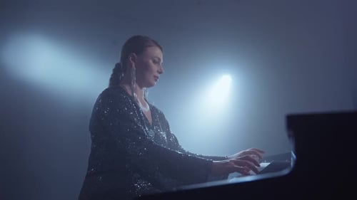 Woman Plays Piano in Dark Blue Lit Room