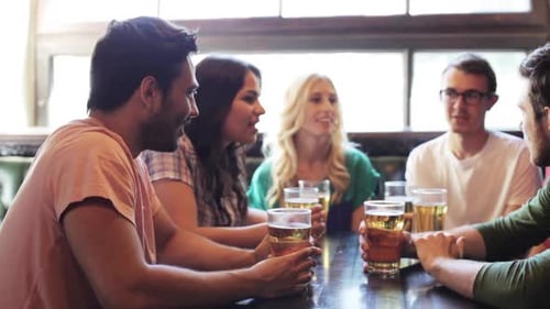 Friends Drinking Beer in Bar Laughing Together
