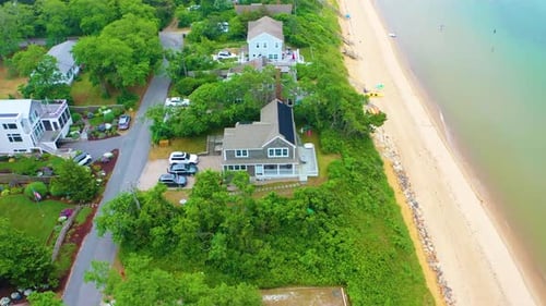 Cape Cod Aerial of Beach Houses and Marshland Beneath Cloudy Skies