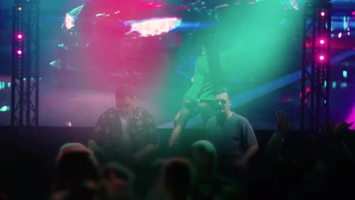 Trendy DJ Playing Electronic Music And Mixing Tracks On DJ Controller People Dancing In Nightclub