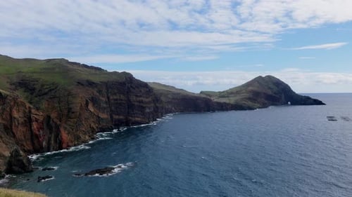 Drone Captures Tranquil Seascape with Rocky Shore and Distant Horizon