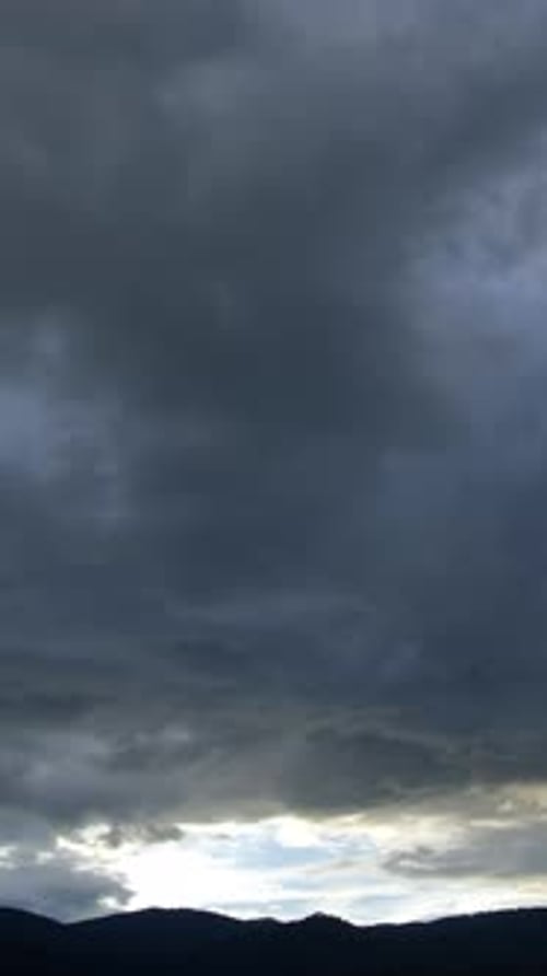 Dramatic Clouds Over Distant Mountain Landscape