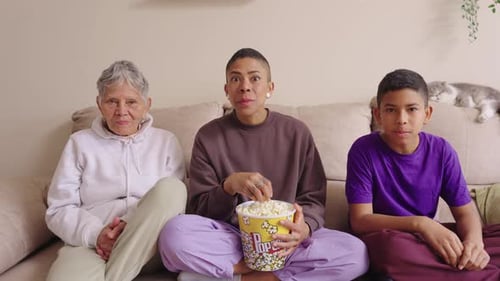 Family Watching TV and Eating Popcorn on Couch