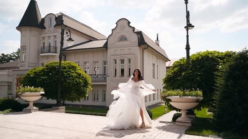 Elegant Bride in White Wedding Gown Twirling Outdoors