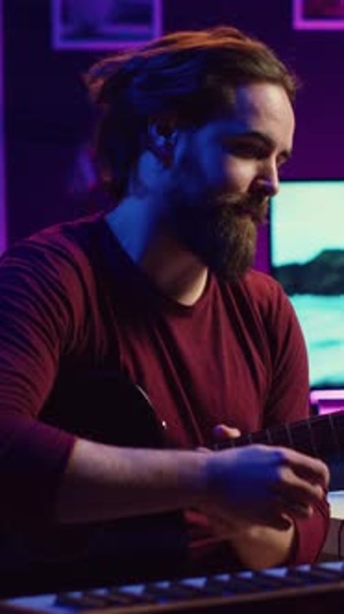 Man Plays Guitar and Keyboard in Neon Studio