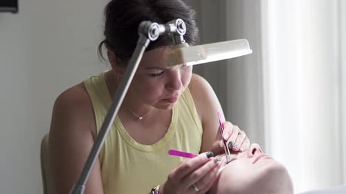 Aesthetician Applies Cosmetic Eyelashes in a Salon