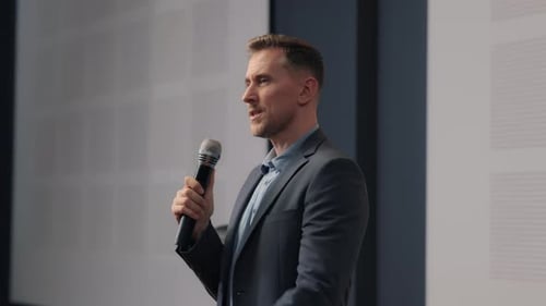 Man Speaking at Corporate Conference Using Microphone