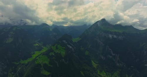 Drone Flies Over Green Picturesque Valley with Mountains in the Background High Mountains Famous