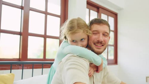 Smiling Father and Daughter Hugging in Bedroom