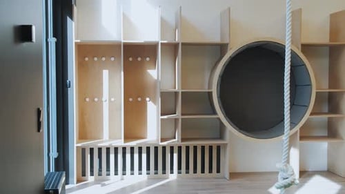 Dolly Shot of Empty Game Room Indoor a Rope Hangs From the Ceiling and Big Circle Shelf and Many