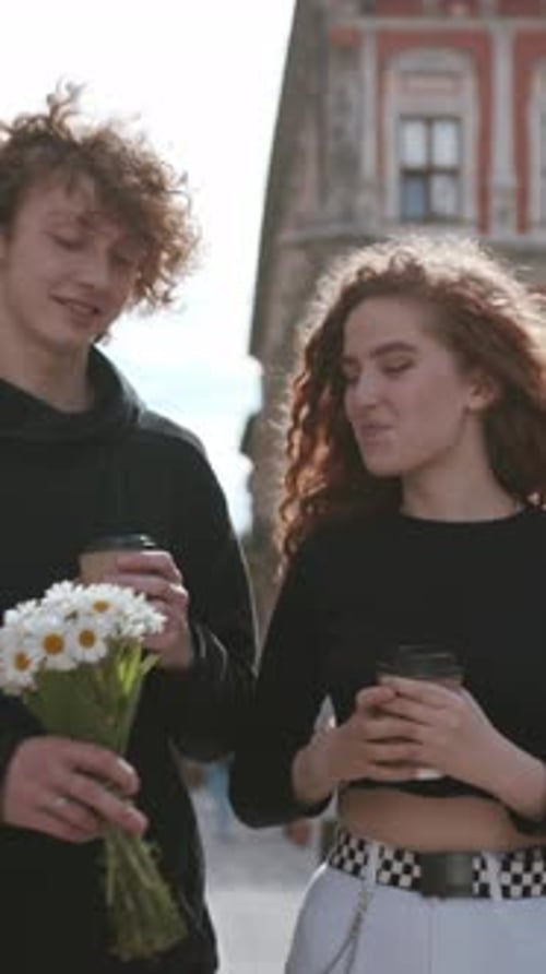 Young Couple Walking, Man Gives Woman Flowers