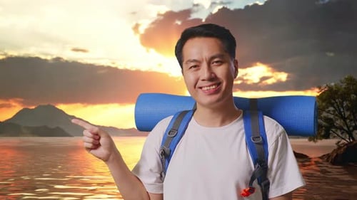 Close Up Of Asian Male Hiker Smiling And Pointing To Side At A Lake