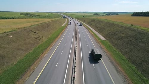 Aerial View of a Cars Driving Through Highway Road Among Agriculture Fields and Green Countryside