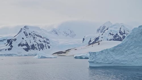 Global Warming and Climate Change in Antarctica with Mountains, Icebergs and Glacier Landscape Scene