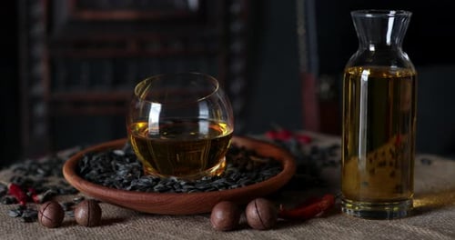 Still Life with Bottle of Cooking Oil and Wooden Plate with Sunflower Seeds
