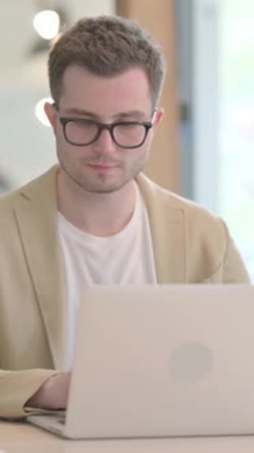 Young Man Working on Laptop Celebrating Success