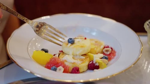 Fork Picking Up Pancake with Berries on Plate