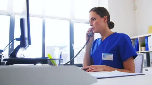Healthcare Worker Speaking on Phone at Desk