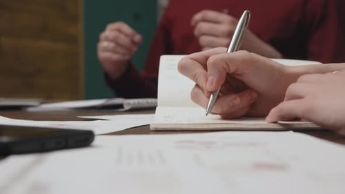 Hände eines Stenografen führen Protokoll bei der Arbeitstagung