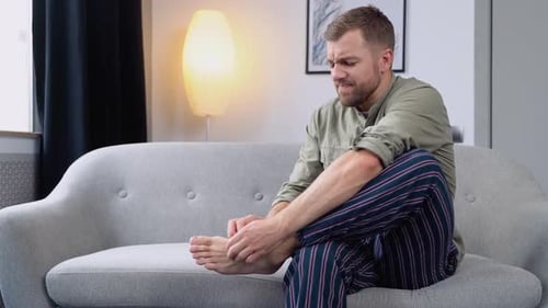 Young Man Scratching His Foot