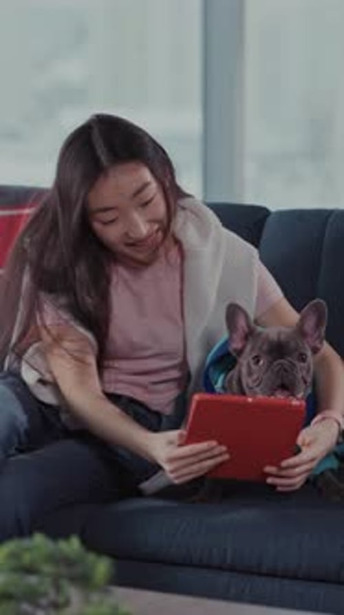 Young Woman Relaxes at Home with Her Dog