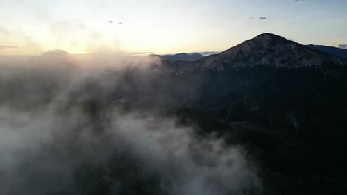 Luftaufnahme niedriger Wolken, die im Morgenlicht mit sanften Hügeln harmonieren