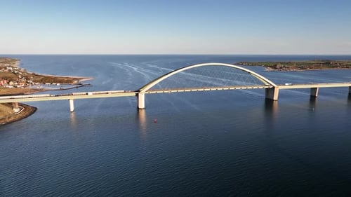 Retreating shot of Fehmarn Sound Bridge (Fehmarnsundbrücke), suspension bridge with steel arches con