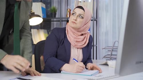 Muslim Colleagues consult and brainstorm about office work.