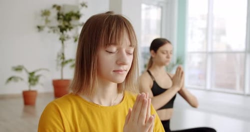 Women Meditating in a Bright Studio