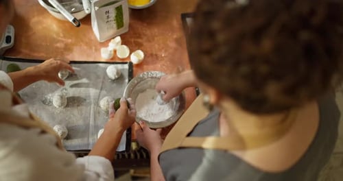Top View Over the Shoulder of Two Confectioner Girls Using Sugar Dust to Prepare a Sweet Dessert in