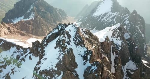 Vista aérea épica de los escarpados picos y valles alpinos cubiertos de nieve