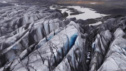 Luftdrift über dem isländischen Gletscher mit Aschestreifen und blauem Eis