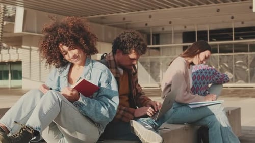 Jungs und Mädchen schreiben Notizen in ein Notizbuch, lesen und arbeiten auf einem Laptop