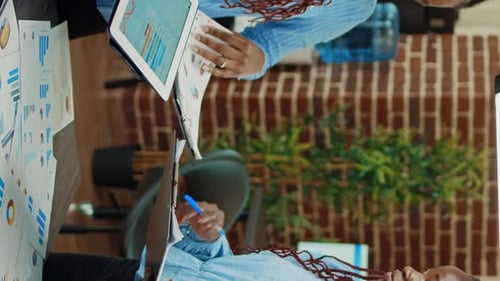 Two Colleagues Analyzing Data in a Bright Office