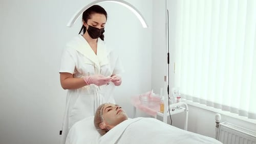 Beautician Wiping Face During Skincare Procedure with Gentle Motion Female Cleaning Face with Soft