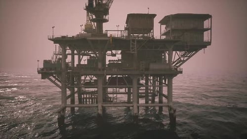 Oil Rig Standing Tall Over Ocean Waves During Cloudy Conditions