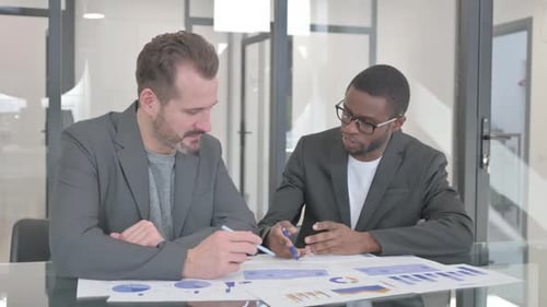 Multiethnic Teammates Doing Paperwork in Office