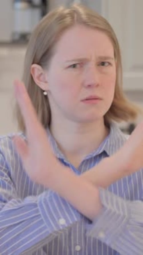 Young Woman Gesturing No with Arms Crossed